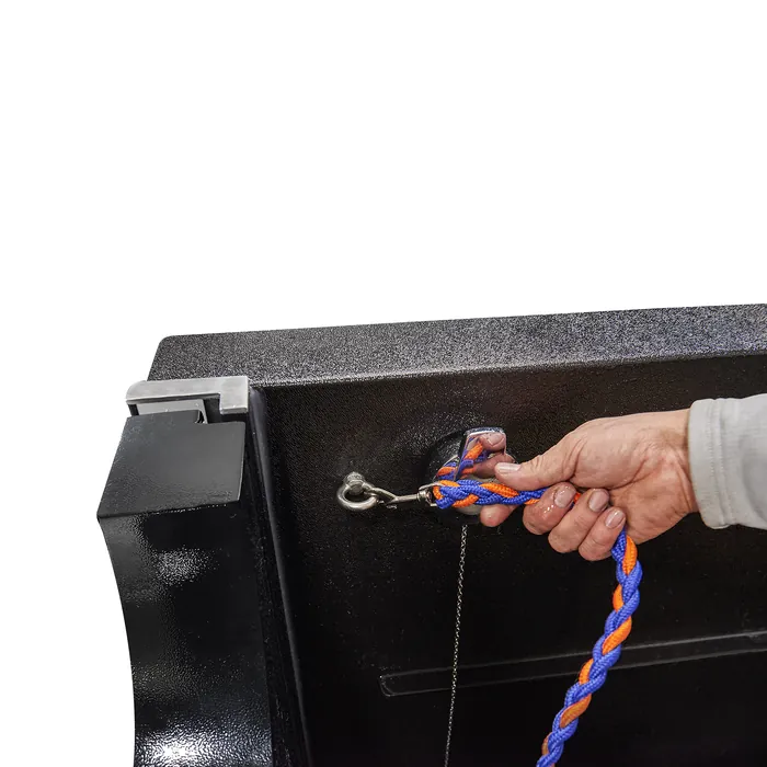 Hand clipping an orange and blue leash to a ring inside the pet tub