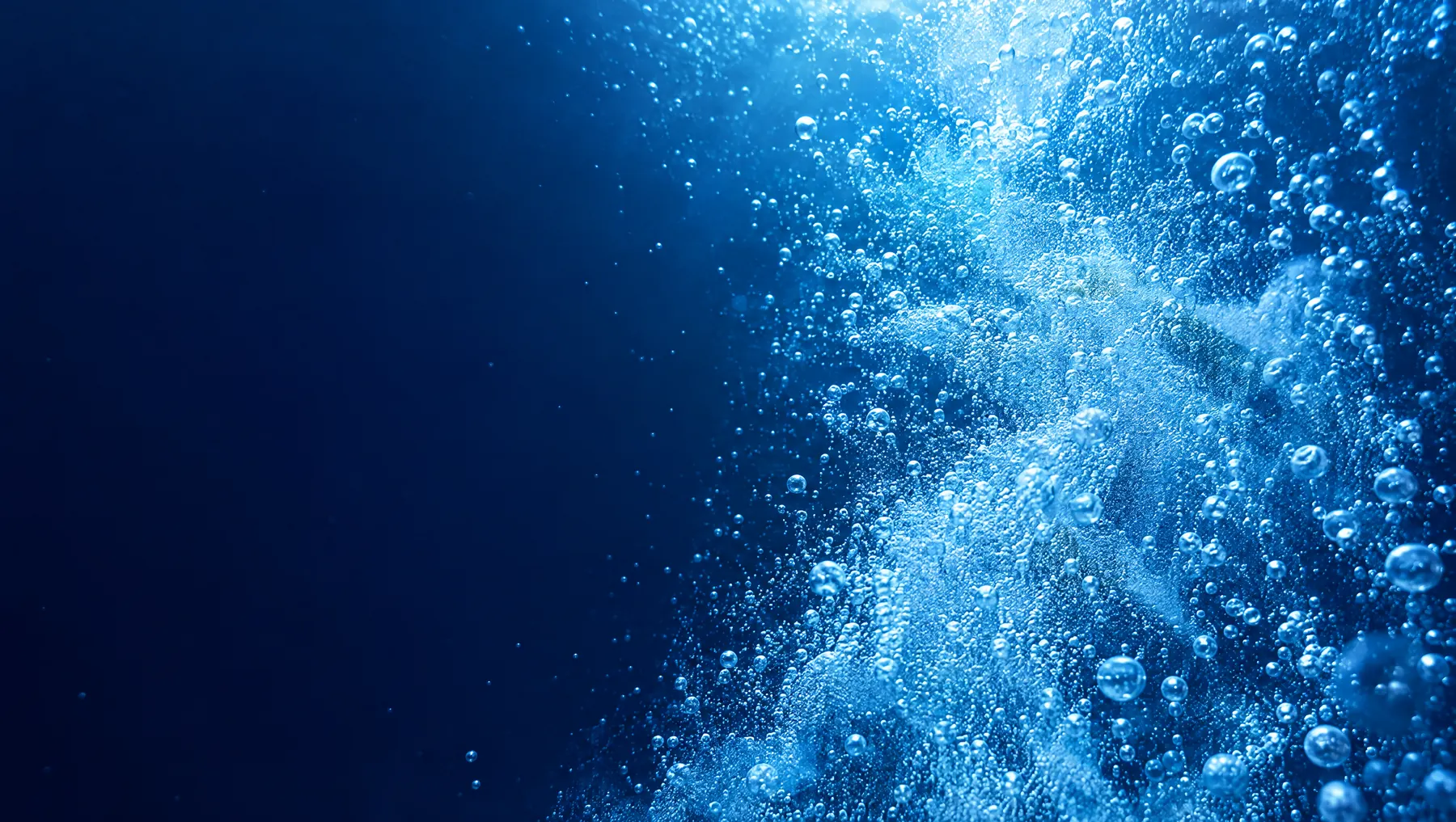Billions of tiny oxygen-rich microbubbles rising through blue water