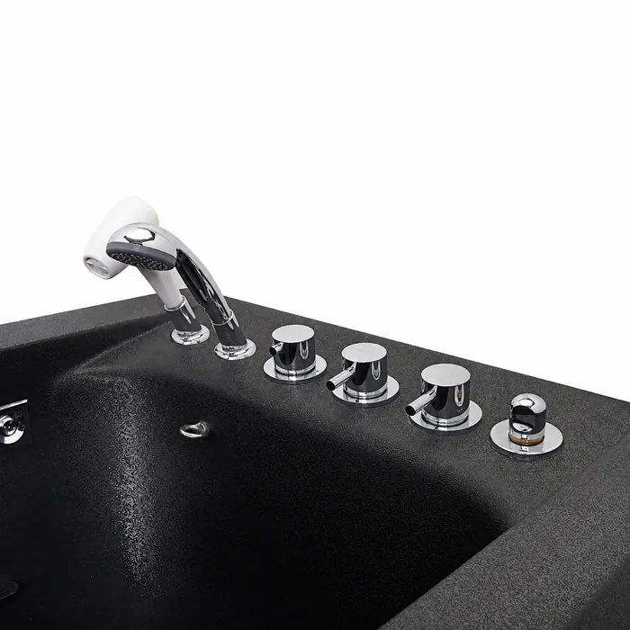 Chrome hand-held shower and control knobs on the rim of the black pet tub